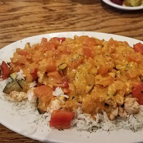 Hearty rice platter smothered in a rich vegetable curry stew with chopped tomatoes